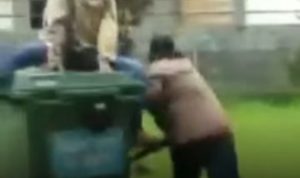 Potongan gambar video sekelompok pemuda berambut pirang yang mendorong dan merobohkan bak sampah