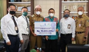 Direktur Operasional Bank Kalsel Ahmad Fatrya Putra menyerahkan bantuan secara simbolis kepada Bupati Tanah Laut H Sukamta, Rabu (222022). (foto.Bank Kalsel).