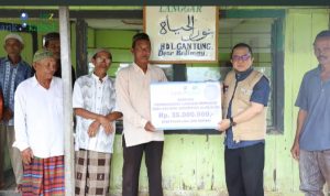 Direktur UPZ Bank Kalsel HM Fajri Muhtadi serahkan bantuan secara simbolis kepada Ketua Langggar Nurhayati Norhadi. (foto.Bank Kalsel)