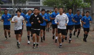 ejumlah pesepak bola dan official Timnas Indonesia berlari saat mengikuti sesi latihan perdana