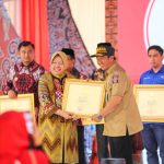 Menteri Sosial RI, Tri Rismaharini (kiri) saat menyerahkan piagam penghargaan