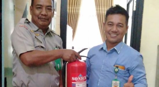 Penyerahan alat pemadam api ringan dari ASN BPBD (kiri) kepada ASN Dukcapil (Kalimantanlive.com/Kamil)