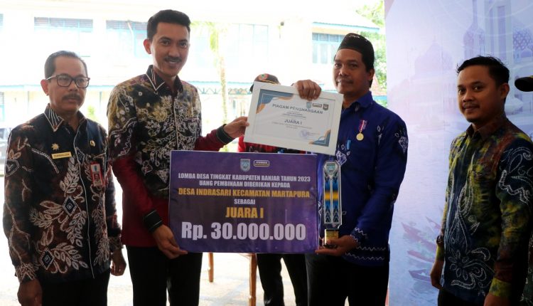 Bupati Banjar H Saidi Mansyur menyerahkan hadiah kepada para pemenang lomba desa tingkat Kabupaten Banjar tahun 2023, di halaman Mahligai Sultan Adam Martapura, Kamis (15/6/2023) pagi. (Kalimantanlive.com)