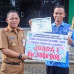 Kepala Dinas Pemberdayaan Masyarakat dan Desa Kabupaten Tanah Bumbu Samsir menyerahkan Reward pemenang Lomba Inovasi Tepat Guna Tingkat Kabupaten, di halaman kantor dinas setempat, Selasa (13/6/2023). (Kalimantanlive.com/ Desy)