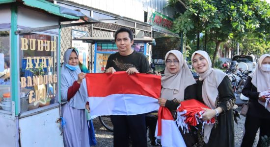 Kepala Dinas Kominfo dan Statistik (Diskominfotik) Kota Banjarmasin, Windiasti Kartika dan jajarannya turun ke Jalan, membagikan bendera merah putih untuk masyarakat, di Jalan Meratus, Kecamatan Banjarmasin Tengah, Kota Banjarmasin, Jumat (28/7/23). (Kalimantanlive.com/Ilham)