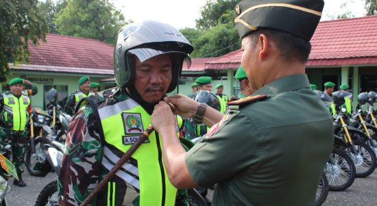 Dandim 1008/Tabalong, Letkol Czi Catur Witanto saat memasangkan helm ke salah satu babinsa (Foto Kodim 1008 tabalong)