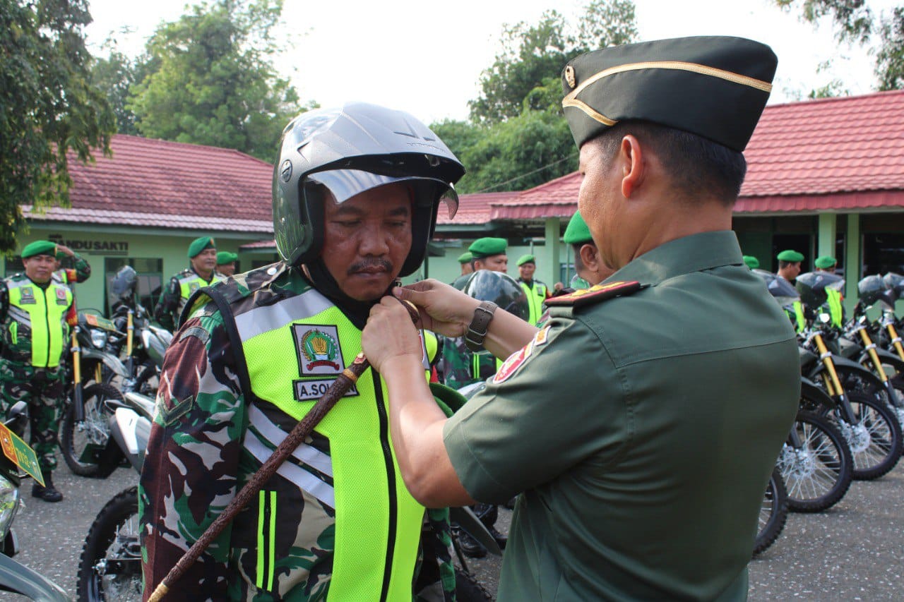 Dandim 1008/Tabalong, Letkol Czi Catur Witanto saat memasangkan helm ke salah satu babinsa (Foto Kodim 1008 tabalong)