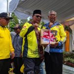 Paman Birin saat membagikan bantuan bendera merah putih kepada Kepala Sekolah SMAN 1 Tanjung, Wagiman. ` (Kalimantanlive.com/ A Hidayat)