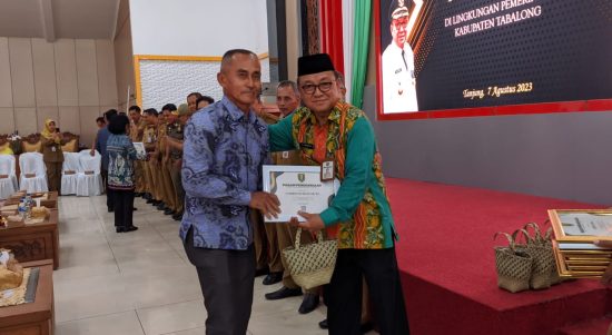 Bupati Tabalong, Anang Syakhfiani saat menyerahkan piagam dan bingkisan kepada salah satu PNS purna tugas (Kalimantanlive.com/ A Hidayat)