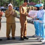 Usai apel gabungan Bupati Banjar H Saidi Mansyur didampingi wakilnya Habib Idrus Al Habsyie dan Plt Kepala Disbudporapar H Irwan Jaya menyerahkan bonus dana pembinaan kepada atlet berprestasi Kabupaten Banjar, di halaman kantornya, Senin (7/8/2023) pagi. (Kalimantanlive.com)