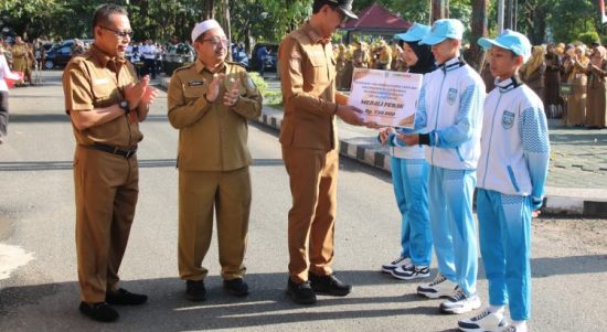 Usai apel gabungan Bupati Banjar H Saidi Mansyur didampingi wakilnya Habib Idrus Al Habsyie dan Plt Kepala Disbudporapar H Irwan Jaya menyerahkan bonus dana pembinaan kepada atlet berprestasi Kabupaten Banjar, di halaman kantornya, Senin (7/8/2023) pagi. (Kalimantanlive.com)