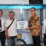 Direktur Utama Bank Kalsel Fachrudin menyerahkan Rombong Barakah kepada salah satu penerima dari kalangan UMKN Prasejahtera di Kalsel. (foto Humas Bank Kalsel)