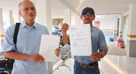 Tatang Suyatman (kanan, menggunakan topi)  merupakan pelapor saat didampingi Penasehat Hukumnya, Evan Chrisentius (kiri) usai menyerahkan laporan dugaan pelanggaran pemasangan APK ke Bawaslu Kalteng, Selasa (22/10/2024).