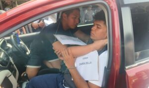 Tersangka kasus pembunuhan, Seili (kiri) sedang memperagakan adegan mencekik korban pada pelaksanaan rekonstruksi di Halaman Mapolresta Banjarmasin, Rabu (21/1/2026).(Foto : Kalimantanlive.com/Frans)